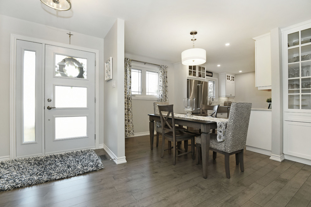 Foto di una piccola sala da pranzo aperta verso la cucina minimal con pareti grigie, parquet chiaro e pavimento grigio
