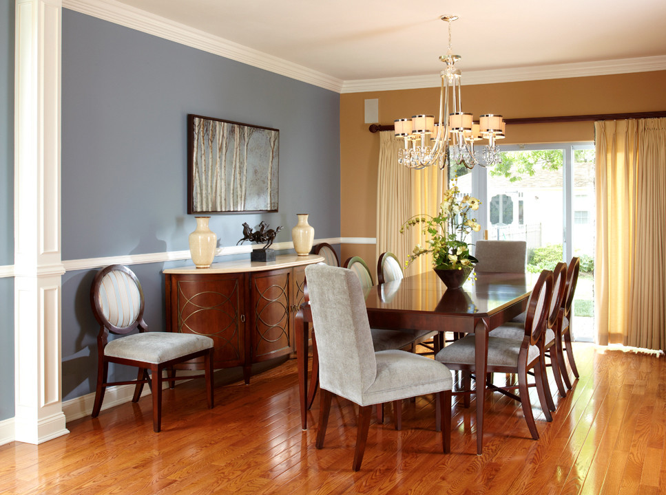 Example of a mid-sized classic medium tone wood floor enclosed dining room design in New York with blue walls and no fireplace