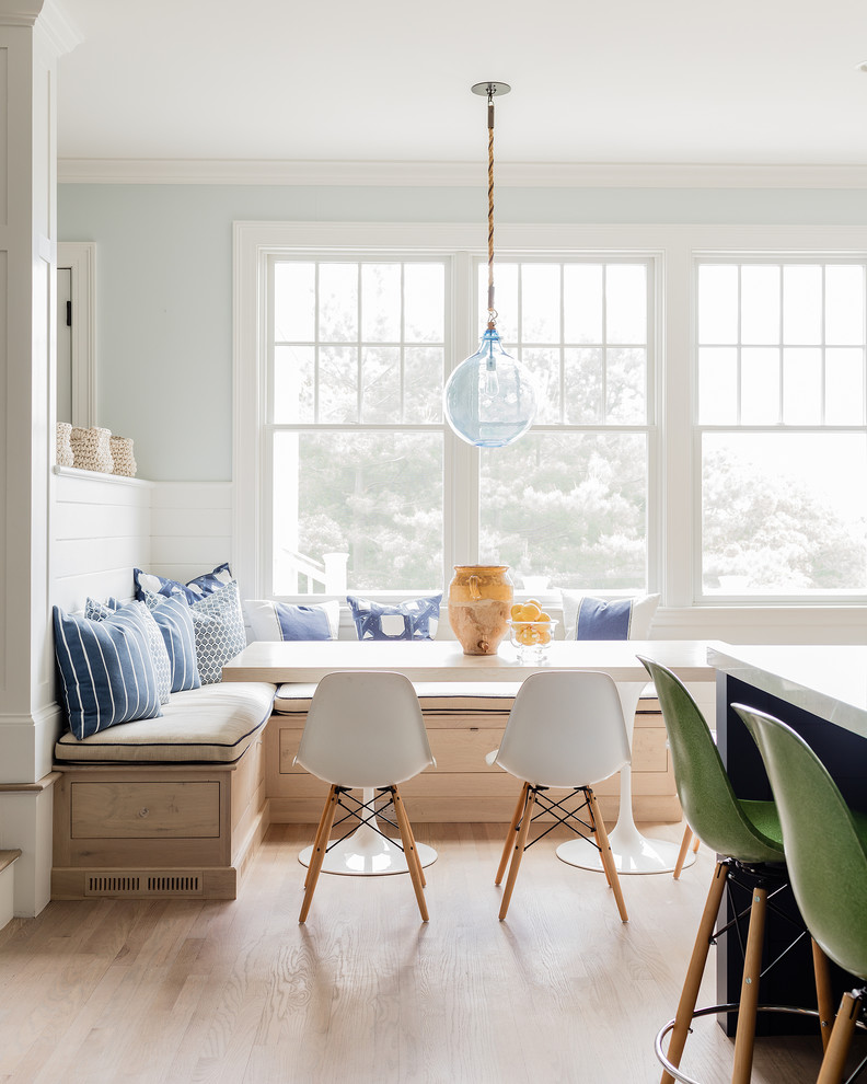 Idee per una sala da pranzo aperta verso la cucina costiera con pareti blu, parquet chiaro, pavimento marrone e pareti in perlinato
