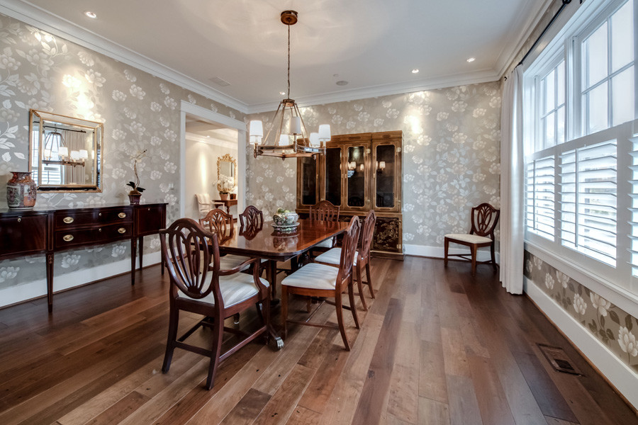 Immagine di una grande sala da pranzo stile americano chiusa con pareti grigie e pavimento in legno massello medio