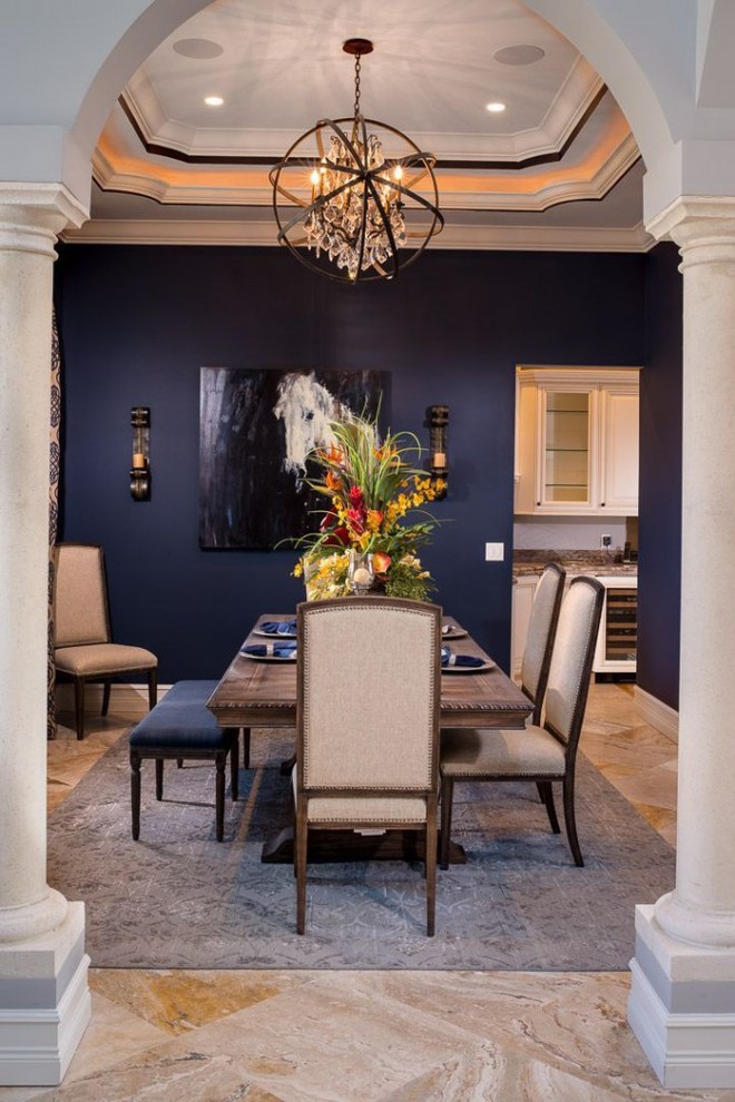 Exemple d'une salle à manger chic fermée et de taille moyenne avec un mur bleu, un sol en calcaire et aucune cheminée.