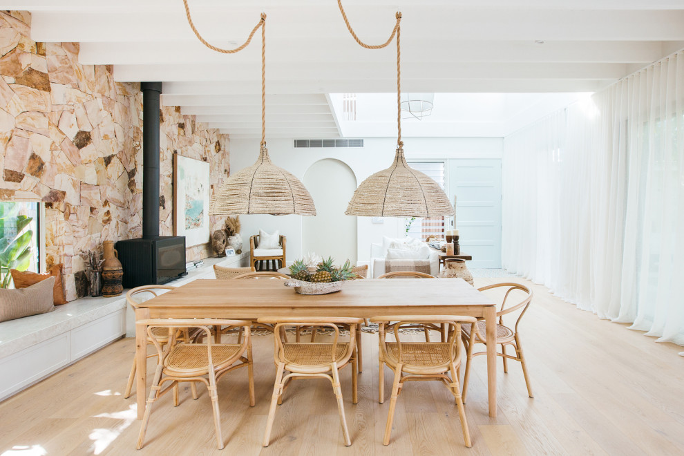 Ispirazione per una sala da pranzo aperta verso il soggiorno stile marino con pareti bianche, parquet chiaro, pavimento beige e travi a vista