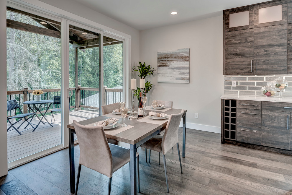 Klassische Wohnküche mit grauer Wandfarbe, hellem Holzboden, Gaskamin, Kaminumrandung aus Stein und braunem Boden in Seattle