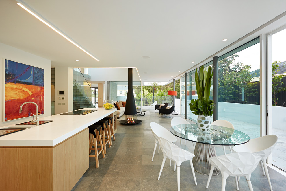 Contemporary dining room in Melbourne with limestone flooring, white walls and a two-sided fireplace.