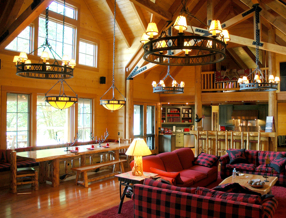 Cette photo montre une très grande salle à manger ouverte sur le salon montagne avec un mur marron, parquet clair, une cheminée standard, un manteau de cheminée en pierre et un sol marron.