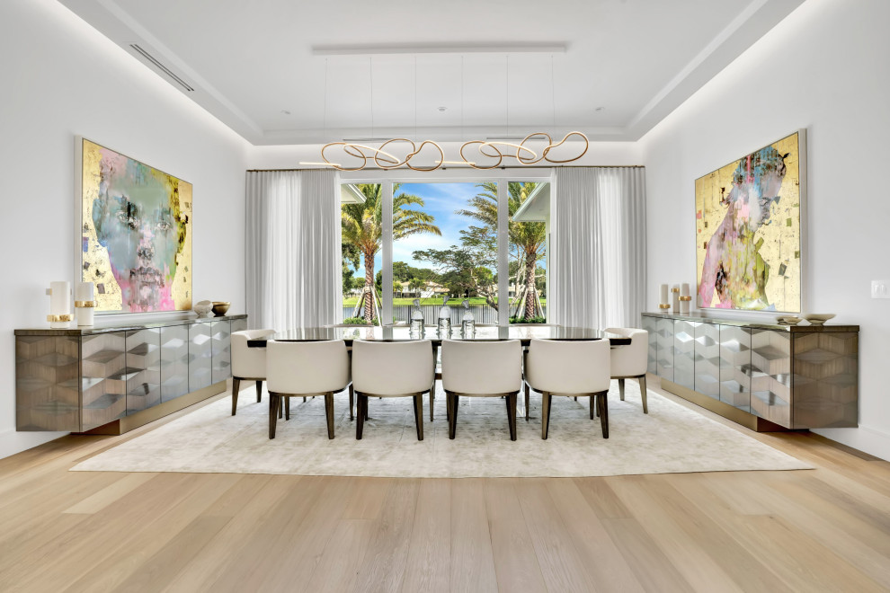 Offenes, Großes Modernes Esszimmer mit weißer Wandfarbe, hellem Holzboden, Tunnelkamin, Kaminumrandung aus Stein, beigem Boden und Kassettendecke in Miami