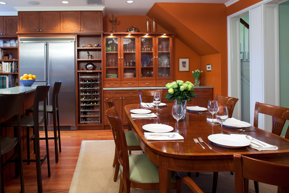 Klassische Wohnküche mit oranger Wandfarbe und braunem Holzboden in New York