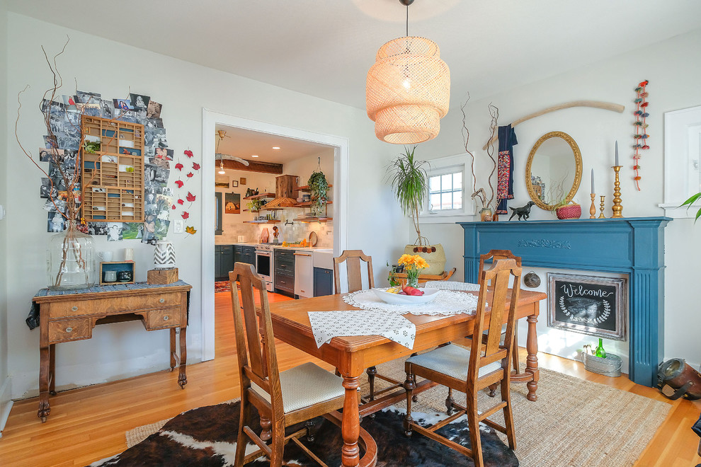 Design ideas for an eclectic enclosed dining room in Portland with white walls and light hardwood flooring.