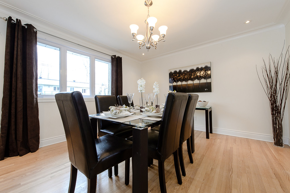 This is an example of a large contemporary enclosed dining room in Montreal with white walls and light hardwood flooring.