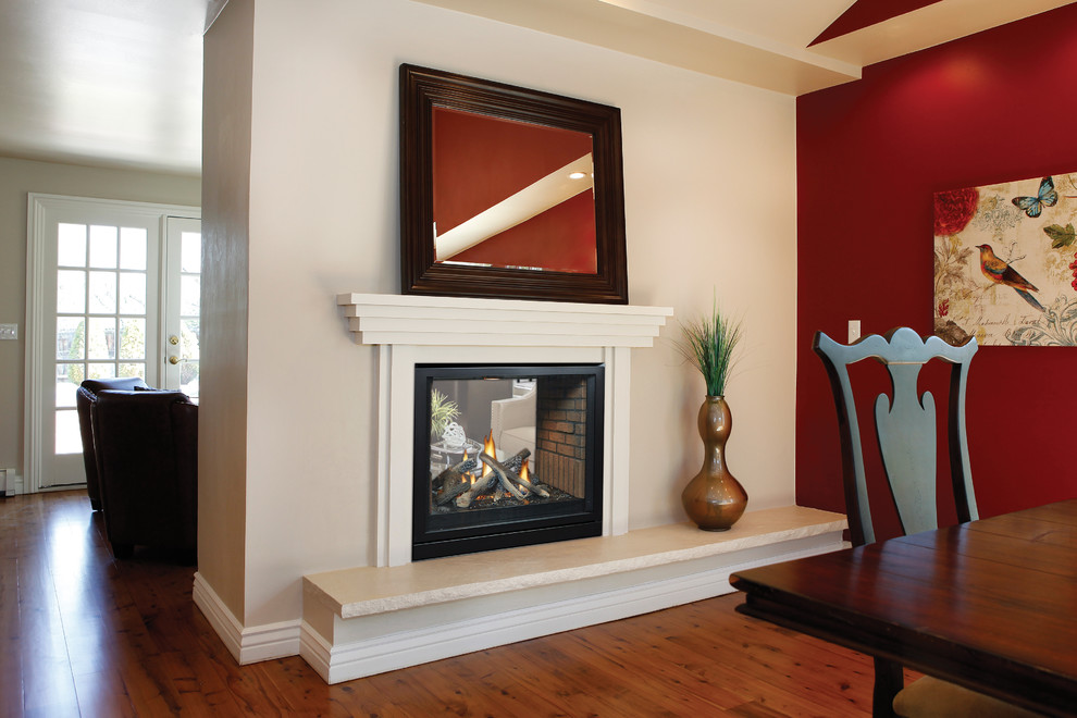 セントルイスにある中くらいなコンテンポラリースタイルのおしゃれなLDK (赤い壁、無垢フローリング、両方向型暖炉、木材の暖炉まわり、茶色い床) の写真