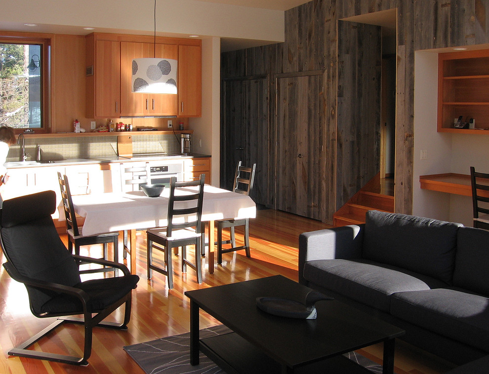 Foto di una sala da pranzo aperta verso il soggiorno moderna di medie dimensioni con pareti beige, parquet scuro, stufa a legna e cornice del camino in metallo