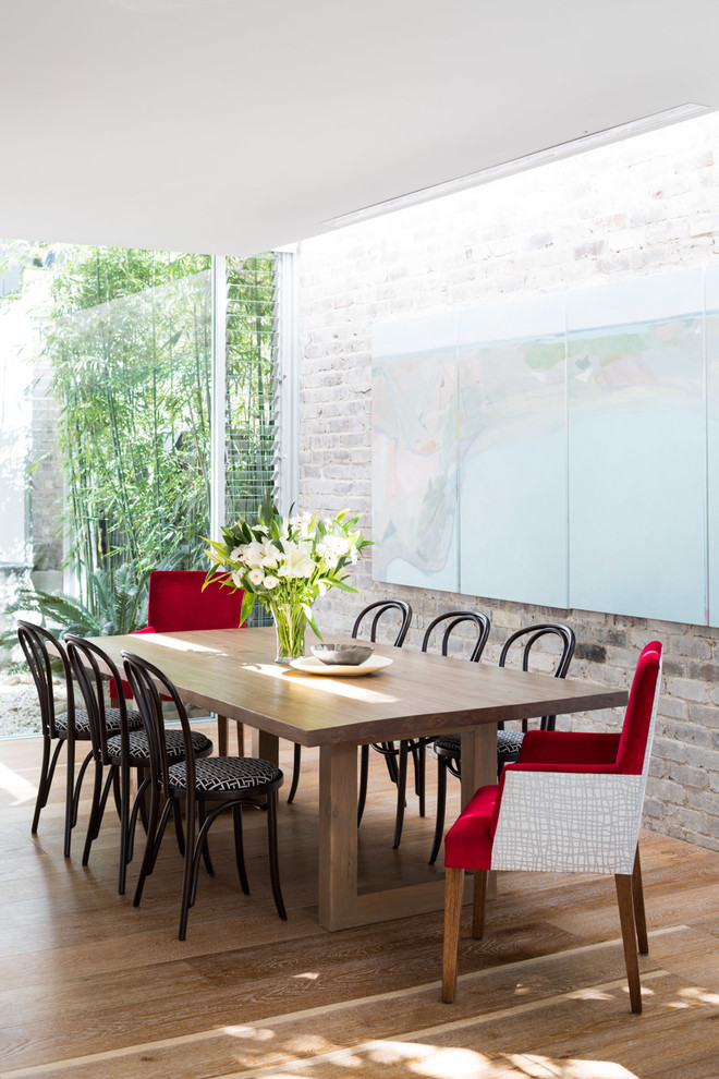 Esempio di una sala da pranzo minimal con pavimento in legno massello medio