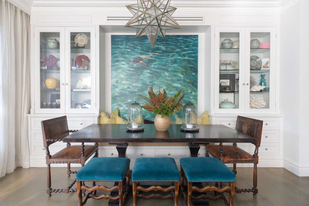 Cette photo montre une salle à manger bord de mer avec un mur blanc et parquet foncé.