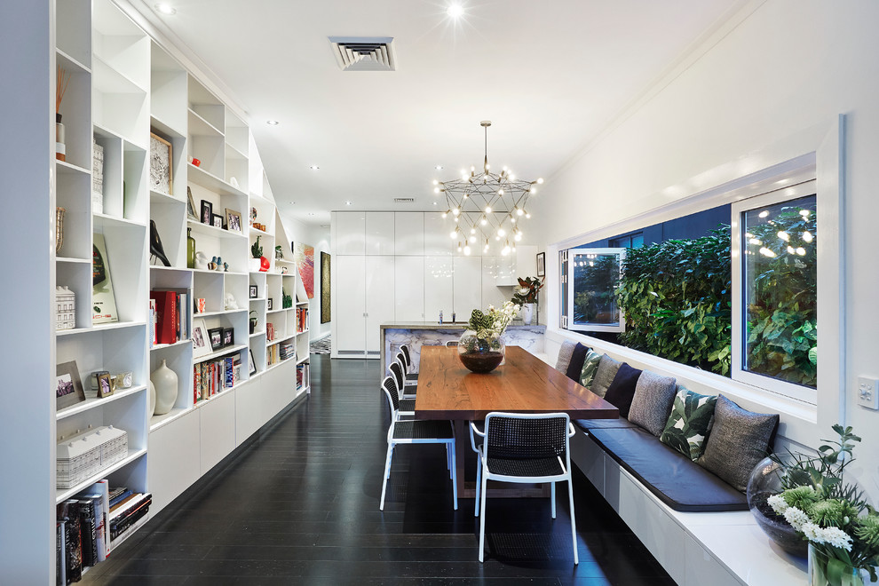 Immagine di una sala da pranzo aperta verso la cucina contemporanea di medie dimensioni con pareti bianche e parquet scuro