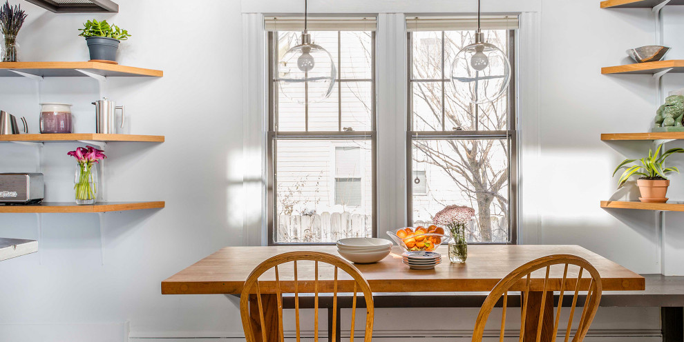Esempio di un piccolo angolo colazione minimal con pareti bianche e parquet chiaro