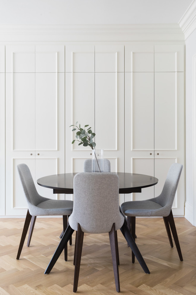 Foto di una sala da pranzo minimal con pareti bianche, pavimento in legno massello medio e pavimento marrone