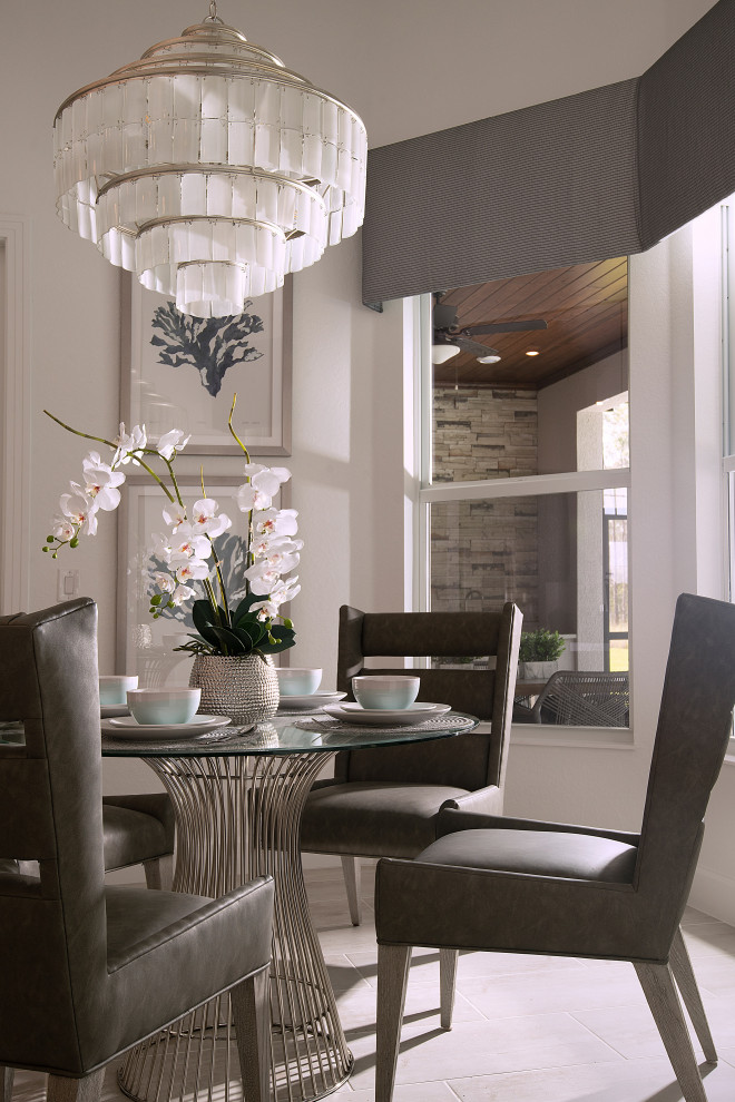 Design ideas for a small coastal dining room in Miami with banquette seating, white walls, ceramic flooring, no fireplace, grey floors and a vaulted ceiling.