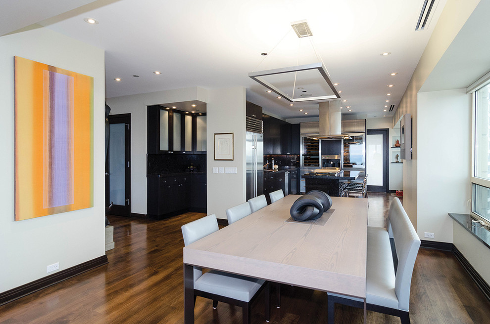 Aménagement d'une salle à manger ouverte sur la cuisine contemporaine de taille moyenne avec un mur blanc et un sol en bois brun.