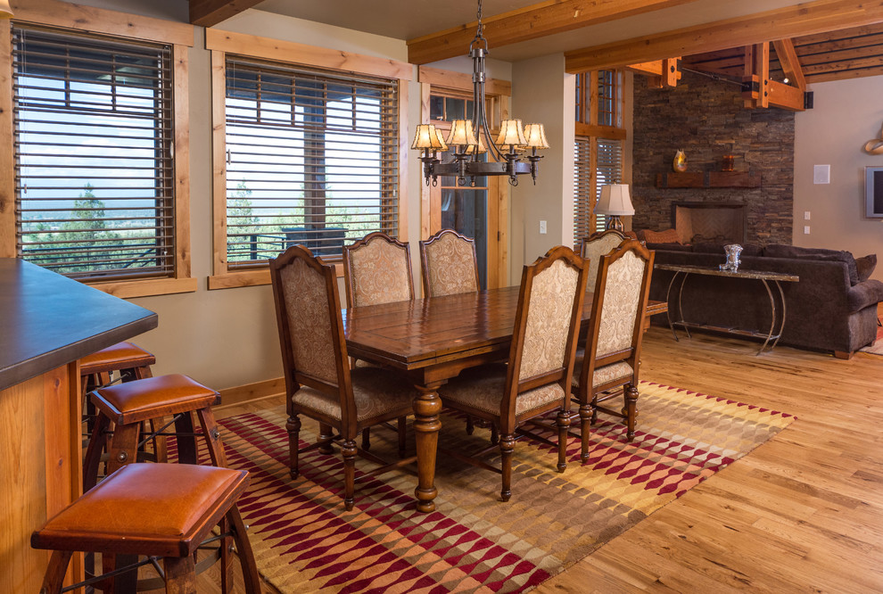 Esempio di una sala da pranzo aperta verso il soggiorno stile rurale con pareti beige e pavimento in legno massello medio