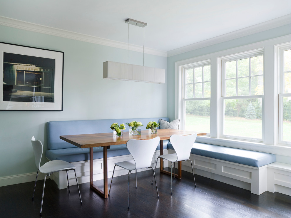 Cette photo montre une salle à manger ouverte sur la cuisine chic avec un mur bleu et parquet foncé.