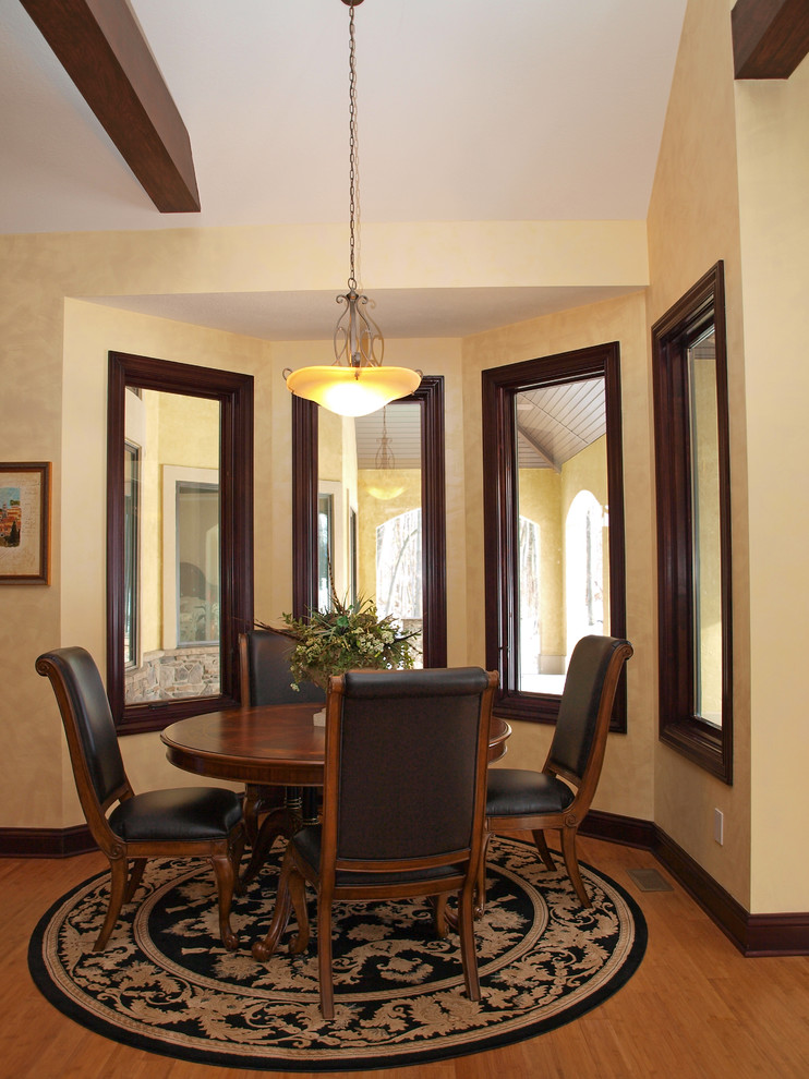 Idee per una sala da pranzo aperta verso la cucina stile americano di medie dimensioni con pareti beige e parquet chiaro