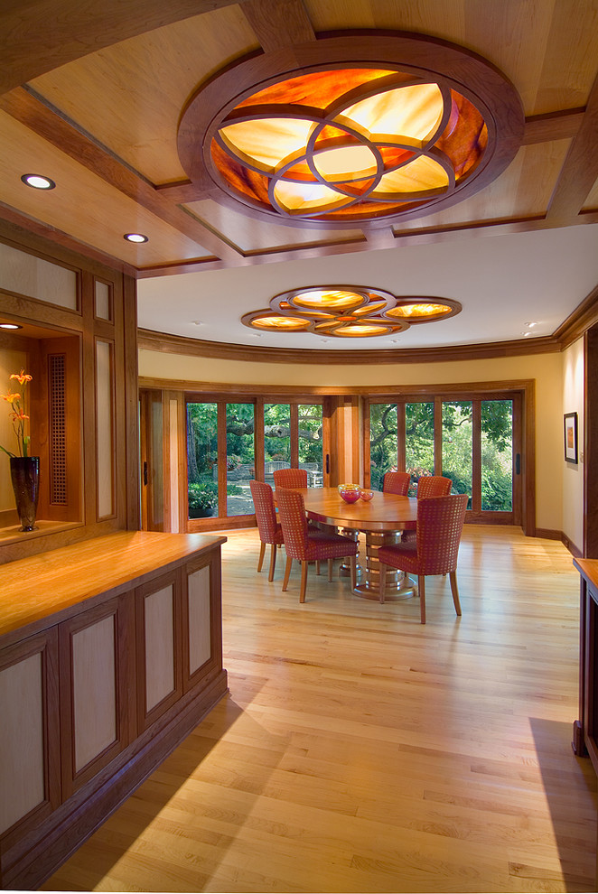 Inspiration pour une salle à manger design avec un mur beige et un sol en bois brun.