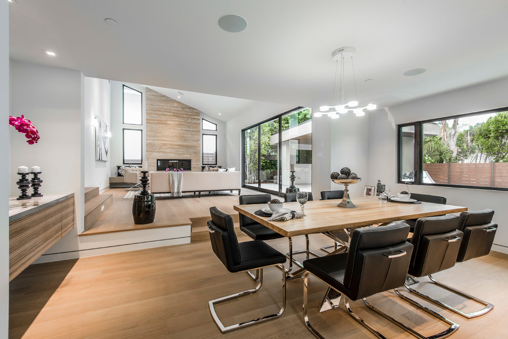Esempio di una sala da pranzo aperta verso il soggiorno design con pareti bianche, pavimento in legno massello medio e pavimento marrone