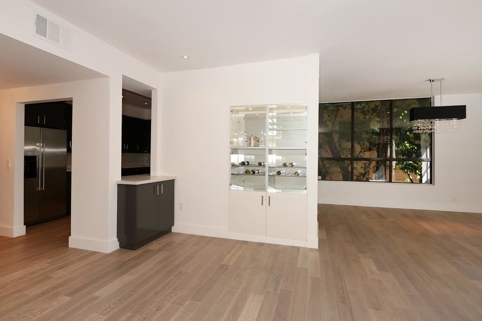 Große Moderne Wohnküche mit weißer Wandfarbe und braunem Holzboden in Los Angeles