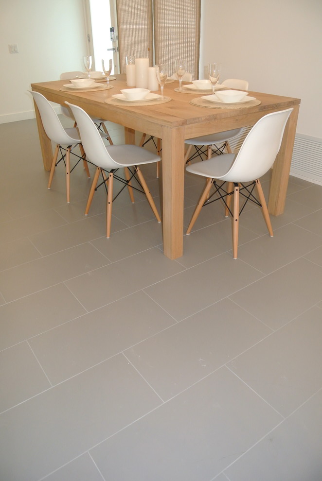 Cette image montre une salle à manger ouverte sur la cuisine minimaliste de taille moyenne avec un mur blanc et un sol en carrelage de porcelaine.