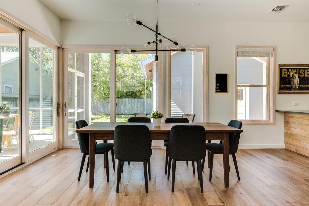 Ispirazione per una sala da pranzo aperta verso la cucina chic con pareti bianche, pavimento in legno massello medio e pavimento marrone