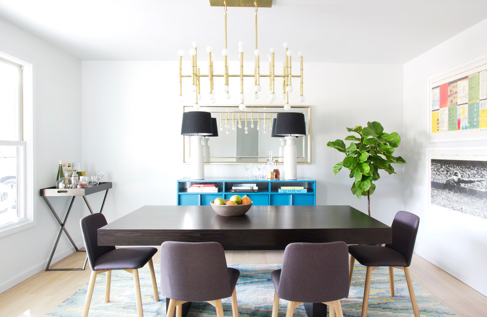 Photo of a midcentury dining room in Austin with white walls, light hardwood flooring and feature lighting.