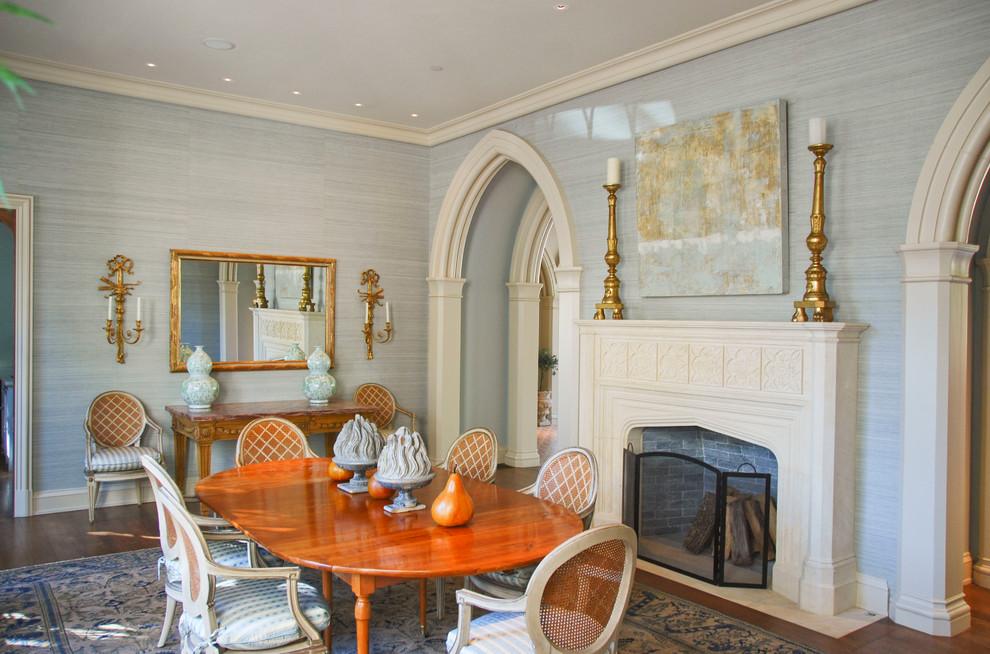 На фото: большая отдельная столовая в классическом стиле с синими стенами, паркетным полом среднего тона, стандартным камином, фасадом камина из штукатурки и коричневым полом