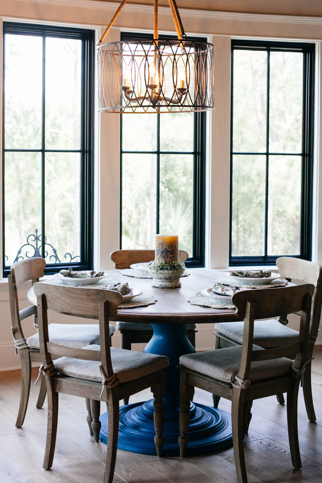 Exemple d'une salle à manger ouverte sur la cuisine chic avec un mur blanc et parquet clair.