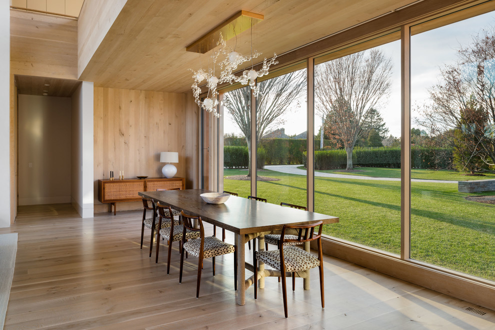 Пример оригинального дизайна: гостиная-столовая среднего размера в современном стиле с светлым паркетным полом, коричневыми стенами и коричневым полом без камина