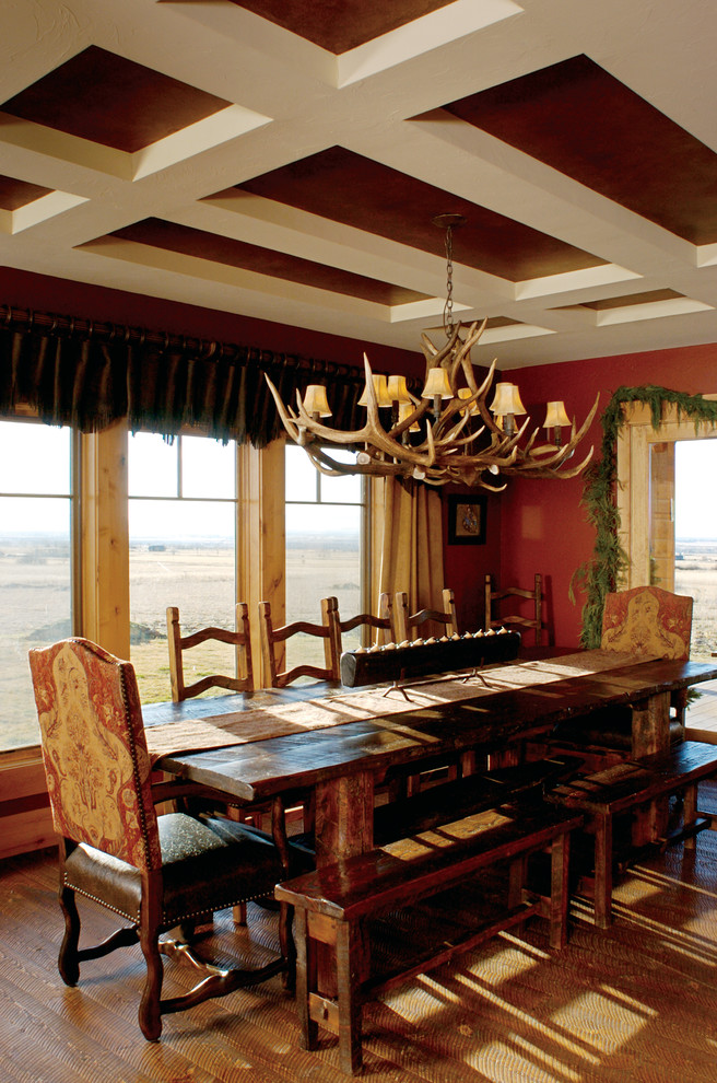Immagine di una sala da pranzo aperta verso la cucina rustica di medie dimensioni con pareti rosse e parquet scuro