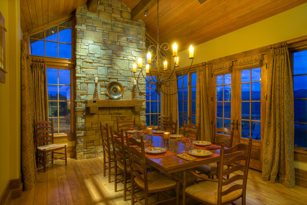 Aménagement d'une grande salle à manger montagne fermée avec un sol en bois brun, un mur beige et une cheminée standard.