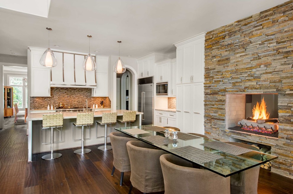 Transitional dark wood floor kitchen/dining room combo photo in Houston with a two-sided fireplace and a stone fireplace