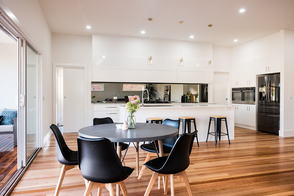 Design ideas for a medium sized contemporary open plan dining room in Melbourne with white walls and medium hardwood flooring.