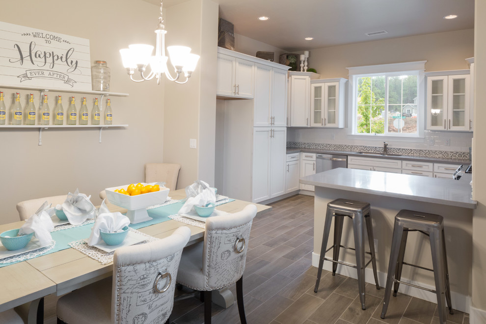 Стильный дизайн: кухня-столовая в современном стиле с серыми стенами, полом из керамической плитки, стандартным камином и фасадом камина из плитки - последний тренд