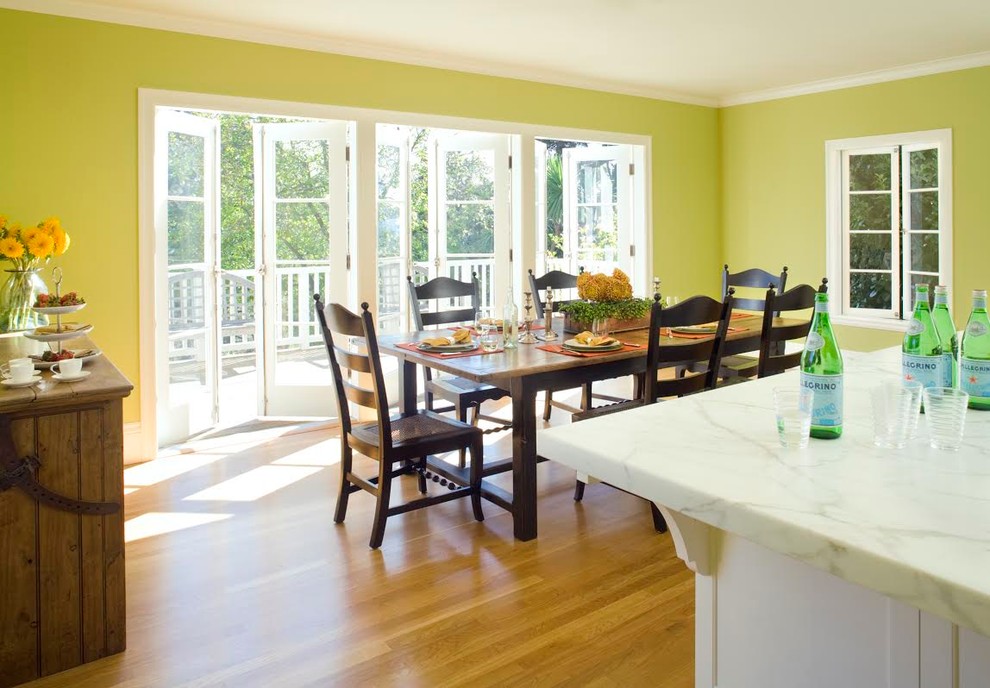 Ispirazione per una sala da pranzo aperta verso la cucina tradizionale di medie dimensioni con pareti verdi e pavimento in legno massello medio