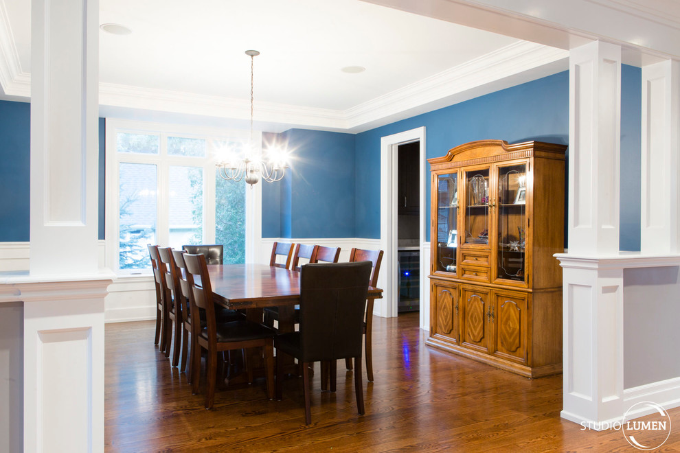 Пример оригинального дизайна: кухня-столовая в современном стиле с синими стенами и темным паркетным полом
