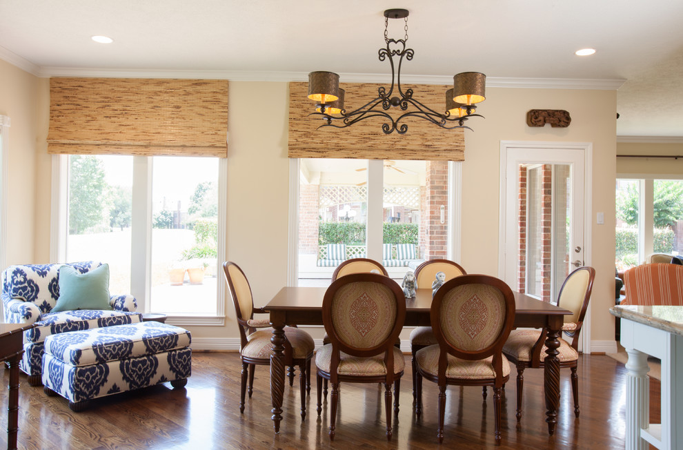 Immagine di una grande sala da pranzo aperta verso la cucina tradizionale con pareti beige e pavimento in legno massello medio