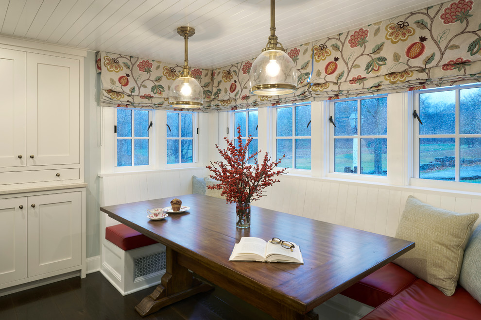 Foto di una grande sala da pranzo aperta verso la cucina country con pareti grigie e parquet scuro