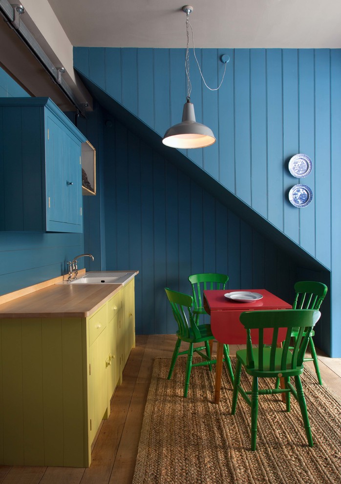 Eclectic dining room in London with blue walls.