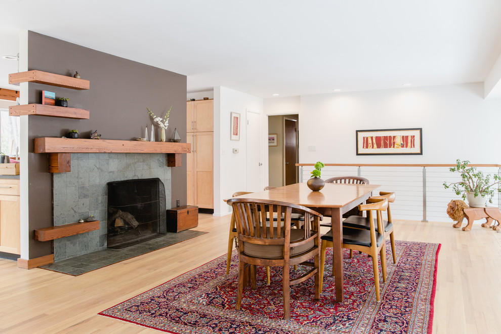 Große Eklektische Wohnküche mit weißer Wandfarbe, hellem Holzboden, Kamin, gefliester Kaminumrandung und beigem Boden in Portland Maine
