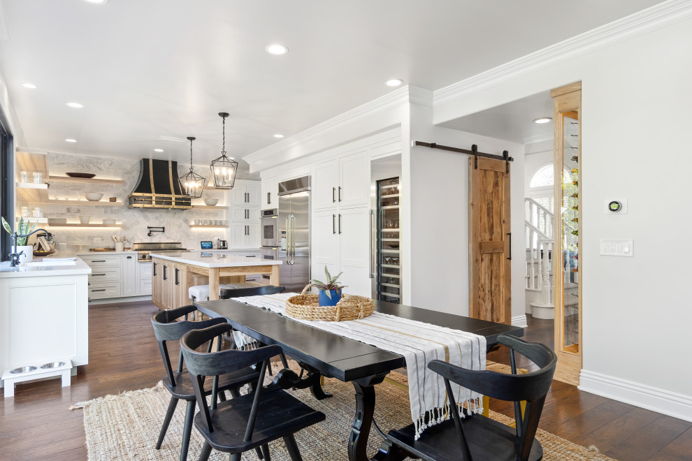 Example of a mid-sized beach style dark wood floor and brown floor kitchen/dining room combo design in Orange County with white walls