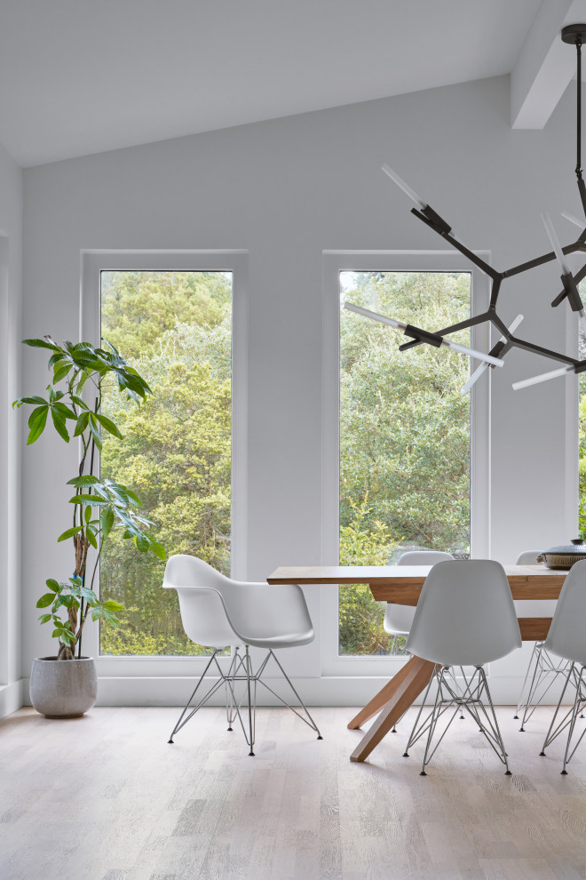На фото: маленькая столовая в стиле модернизм с белыми стенами, светлым паркетным полом и коричневым полом для на участке и в саду с