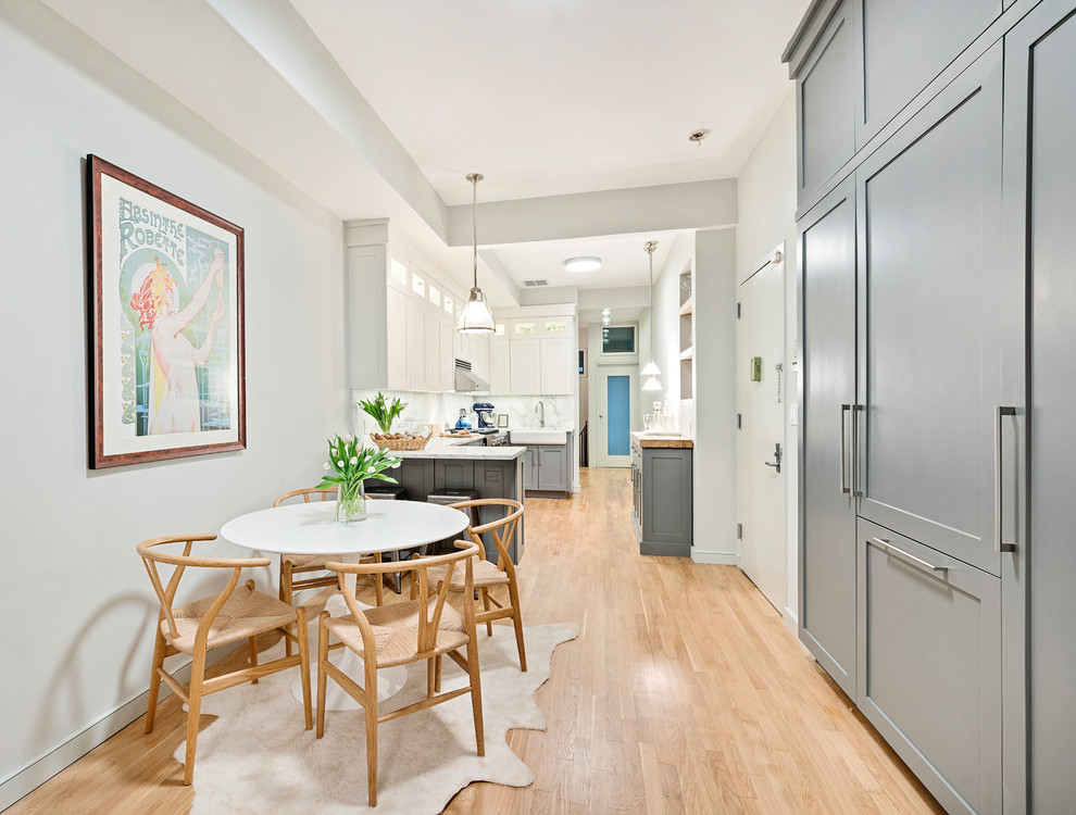 Cette image montre une salle à manger ouverte sur la cuisine nordique de taille moyenne avec un mur gris.
