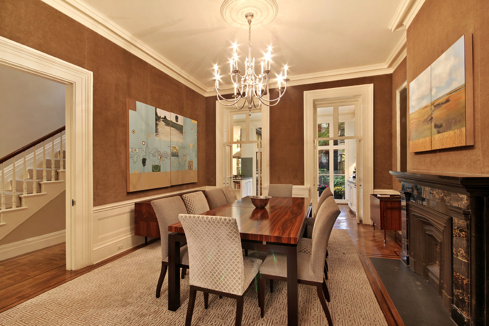 This is an example of a medium sized traditional open plan dining room in New York with brown walls, carpet, a standard fireplace and a stone fireplace surround.