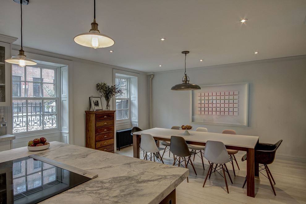 Cette photo montre une salle à manger ouverte sur la cuisine moderne avec un mur gris et parquet clair.